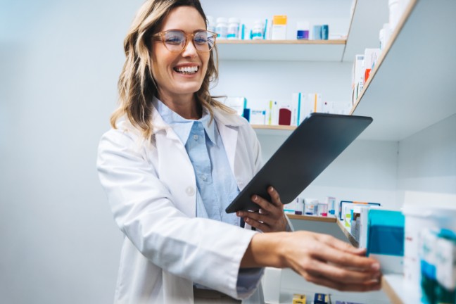 Female doctor looking at tablet and grabbing medicine