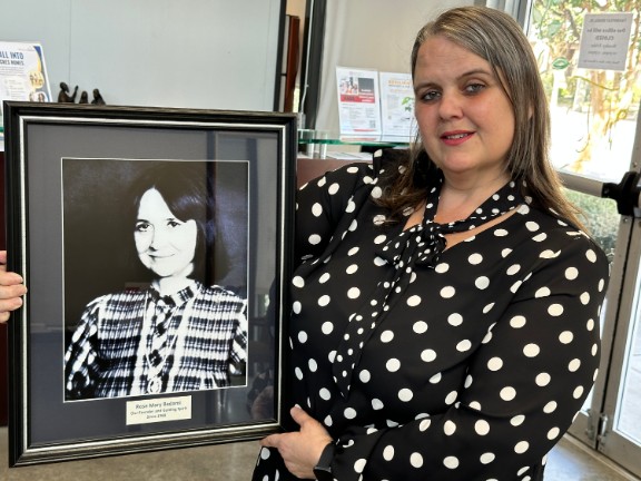 Gina Monti with portrait of MHI Founder