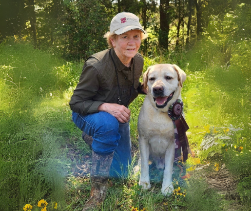 Paula Graves in a field with her dog