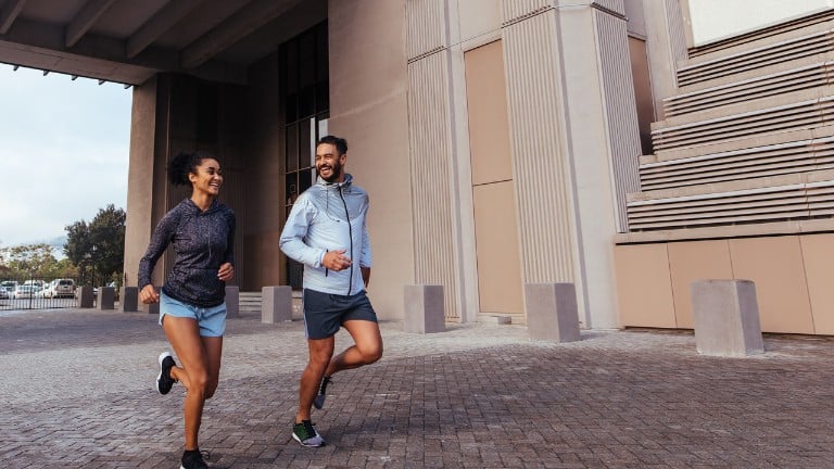 Two people running and smiling